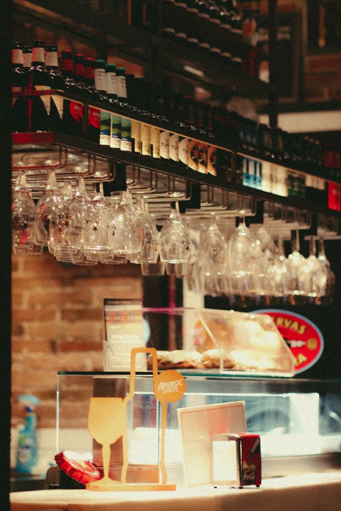 A stylish display of hanging glassware and bottles at an indoor bar, offering a chic ambiance.