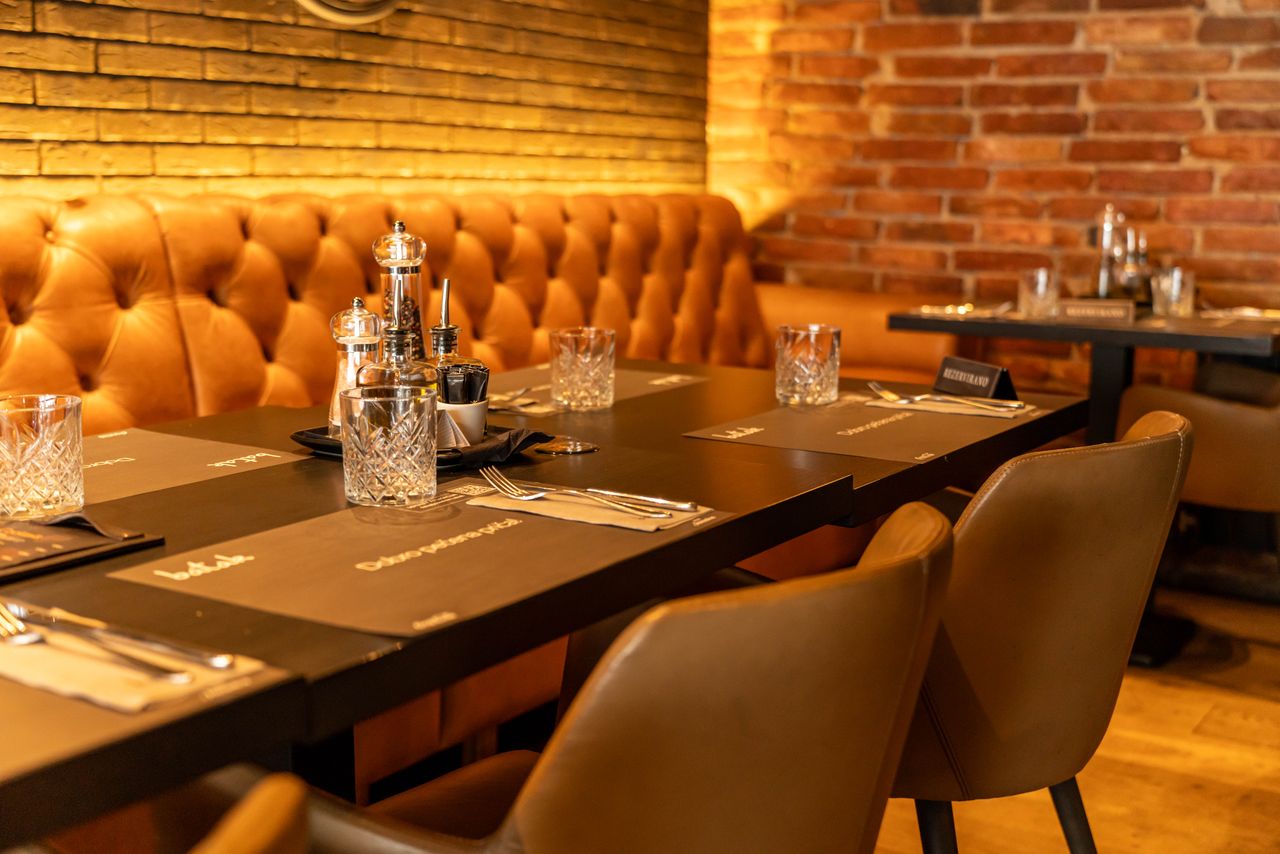 Warm and inviting restaurant setting with elegant leather seating and table setting.