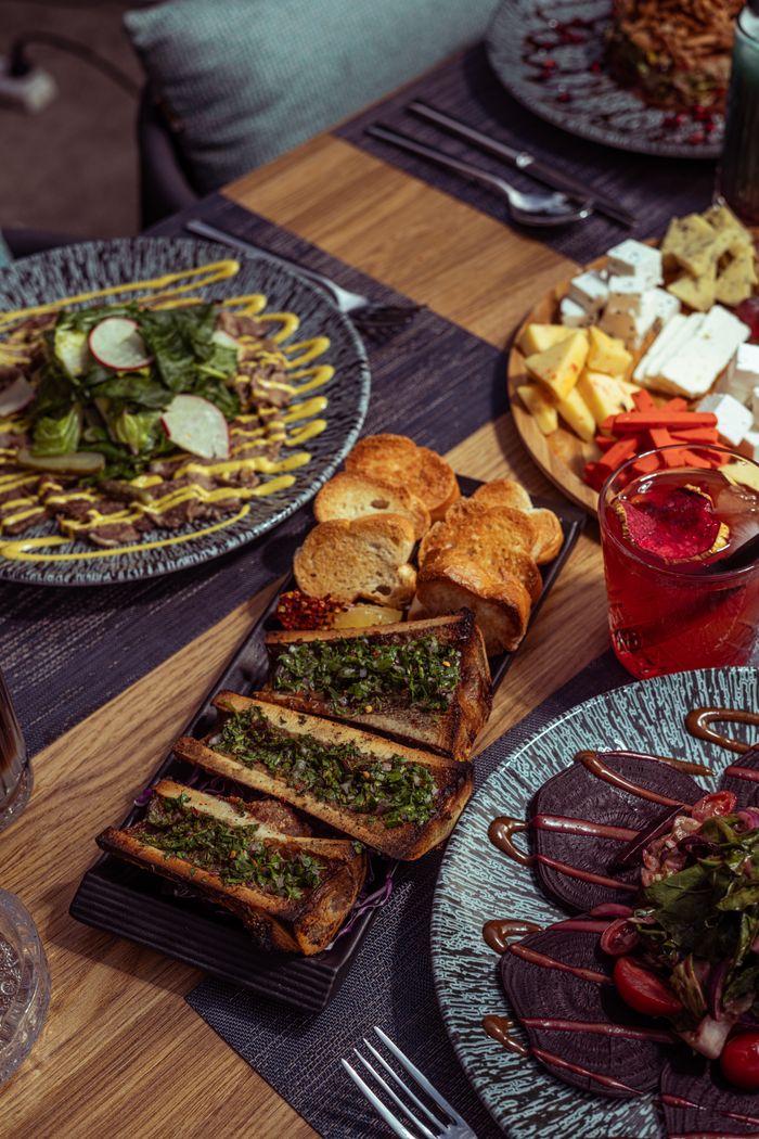 Savory dishes and drinks arranged elegantly on a wooden table in Baghdad, Iraq.