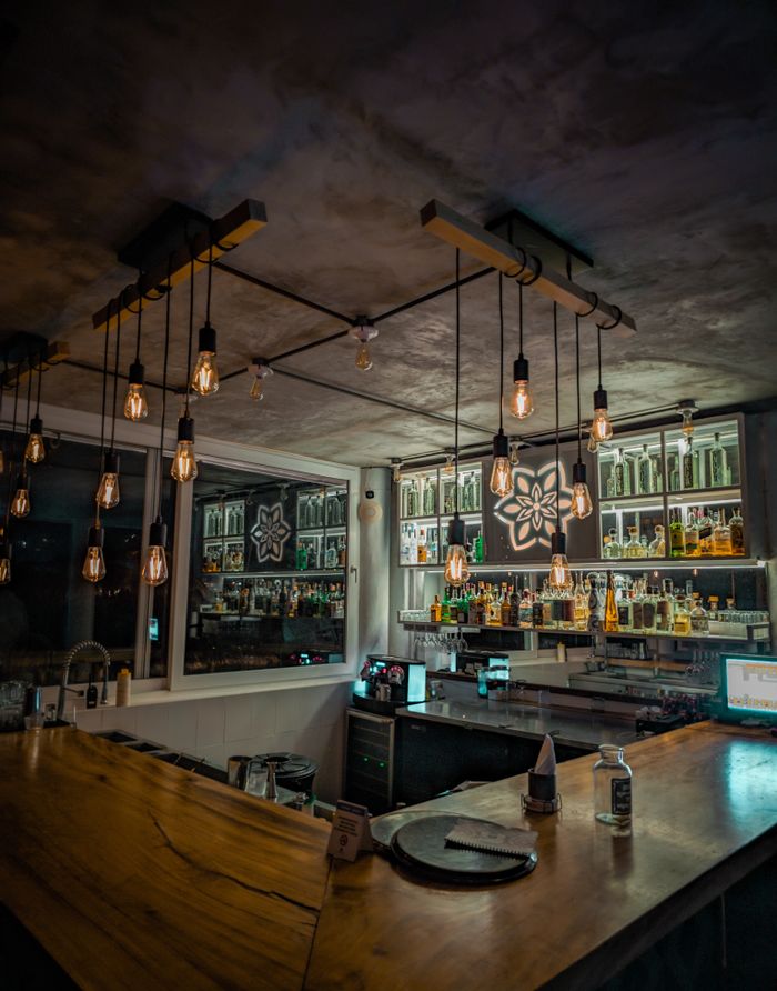 Cozy bar interior with vintage lighting and wooden decor.