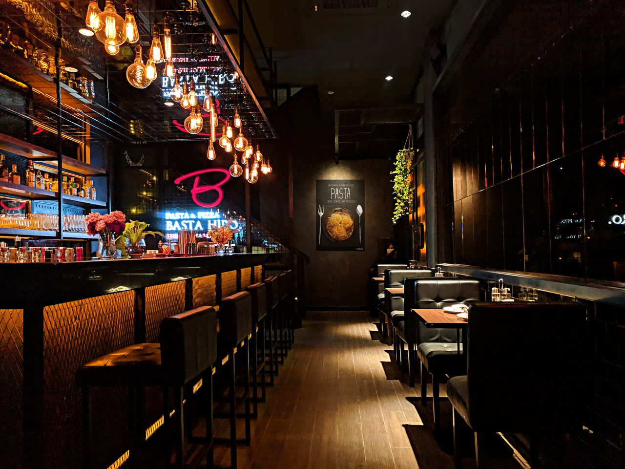 Elegant restaurant bar with ambient lighting, showcasing contemporary interior design and cozy seating.